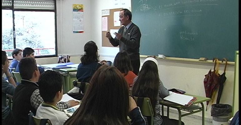 Un profesor dando clase a alumnos en un colegio público