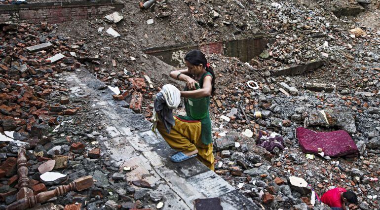 Una mujer nepalí carga con un bidón de agua en Thamel, Katmandú (Nepal) el 23 de julio de 2015. Tras los graves destrozos causados por el terremoto que asoló Nepal 