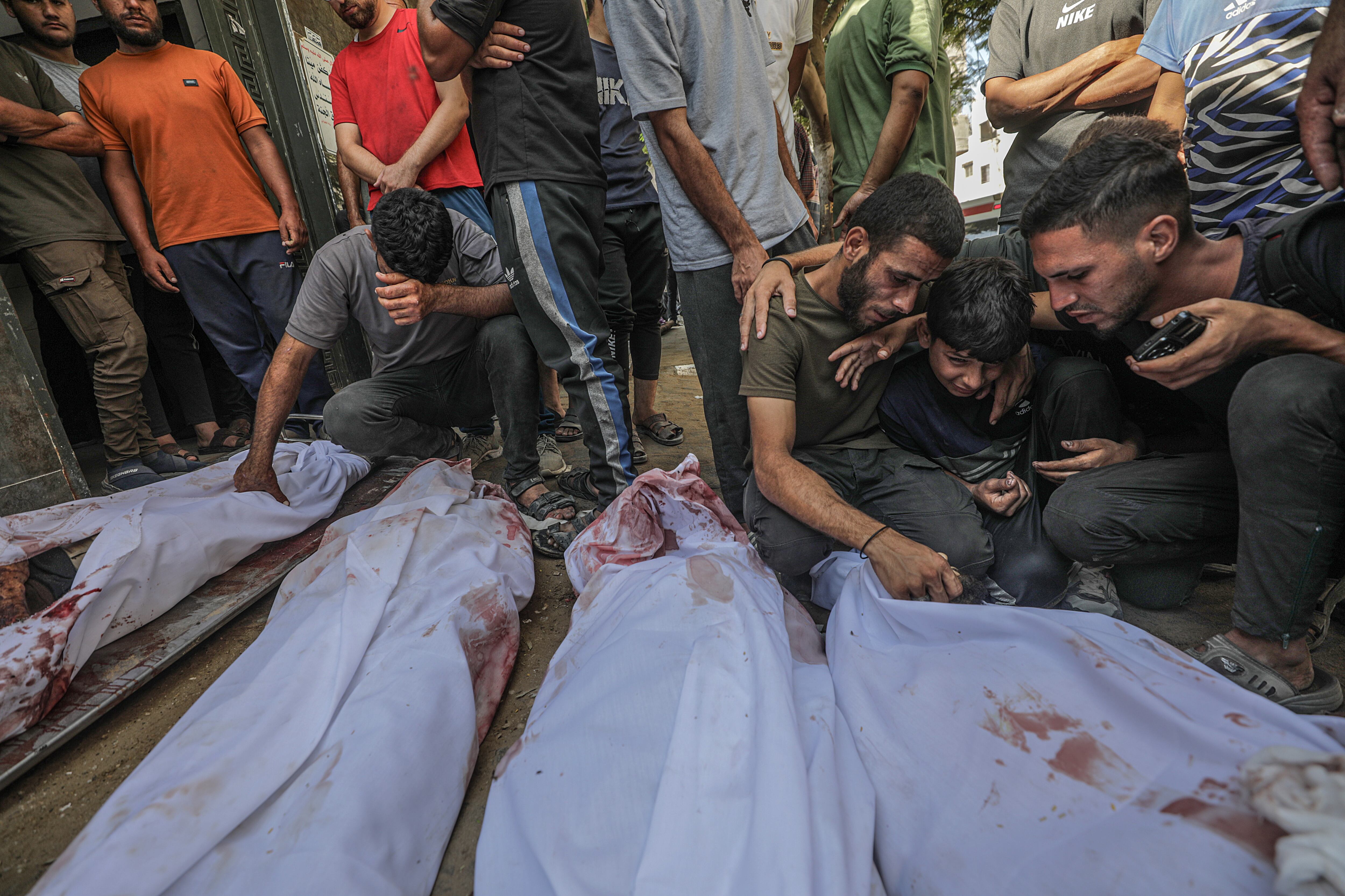 Palestinos lloran junto a los cuerpos cubiertos de sus familiares en el hospital Al Shifa de la ciudad de Gaza, en la Franja de Gaza, el 31 de agosto de 2025. 