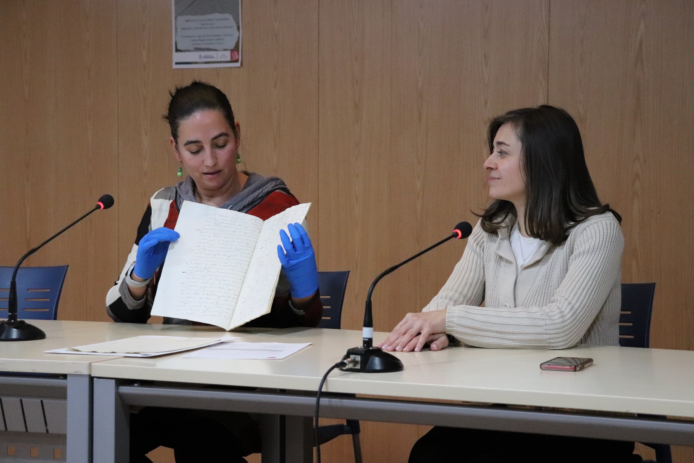 Elvira Rodríguez, archivera municipal, muestra a los vecinos los documentos recuperados, en presencia de Raquel Jimeno, alcaldesa del municipio.