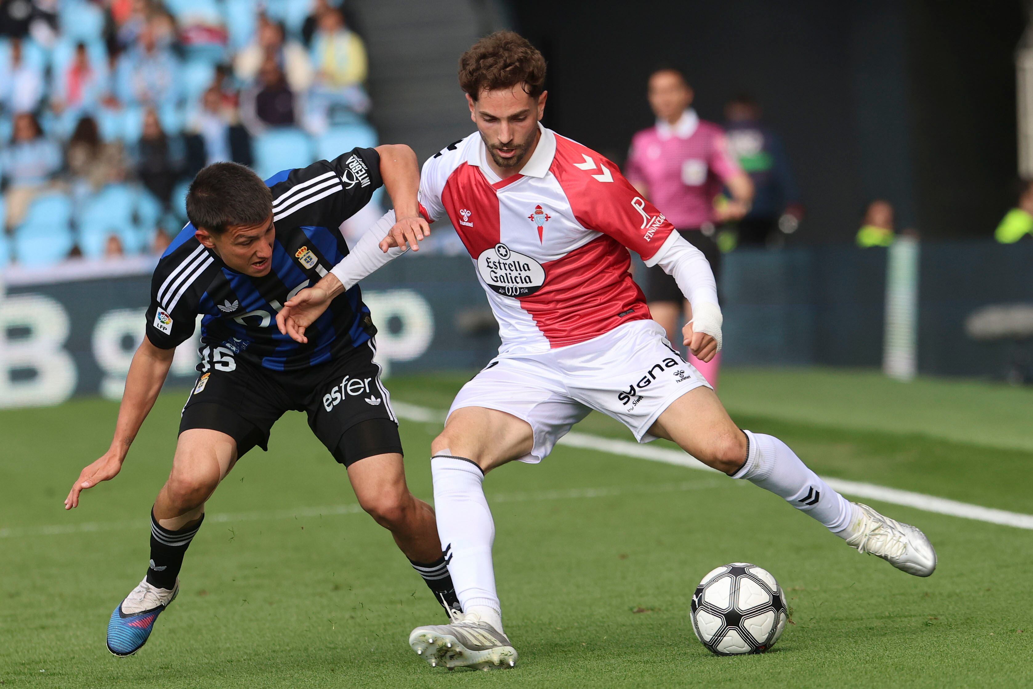 VIGO (PONTEVEDRA), 12/04/2026.- El defensa del Celta Javi Rueda (d) juega un balón ante Thiago Fernández, del Oviedo, durante el partido de LaLiga de fútbol que Celta de Vigo y Real Oviedo disputan este domingo en el estadio de Balaídos. EFE/Salvador Sas