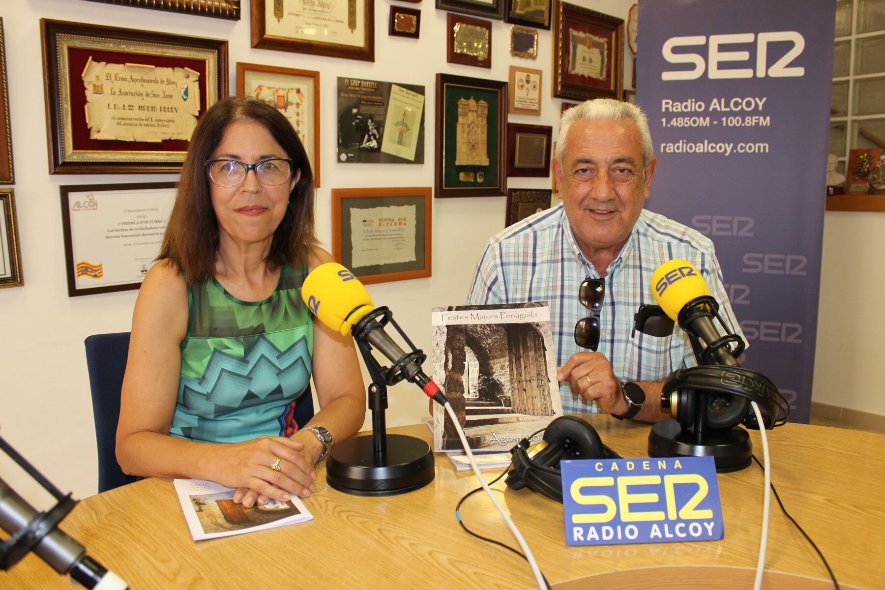 Mari Carmen Blanes i Salvador Català en els estudis centrals de Radio Alcoy amb el programa d'actes de les Festes de Penàguila