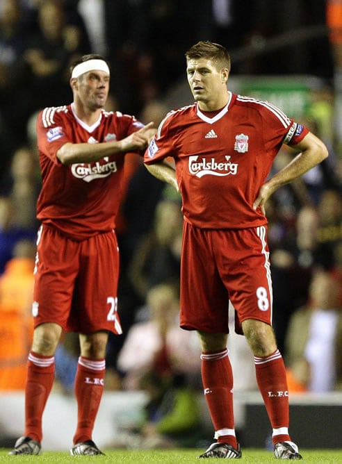 Gerrard y Carragher con gesto serio durante el partido ante el Aston Villa