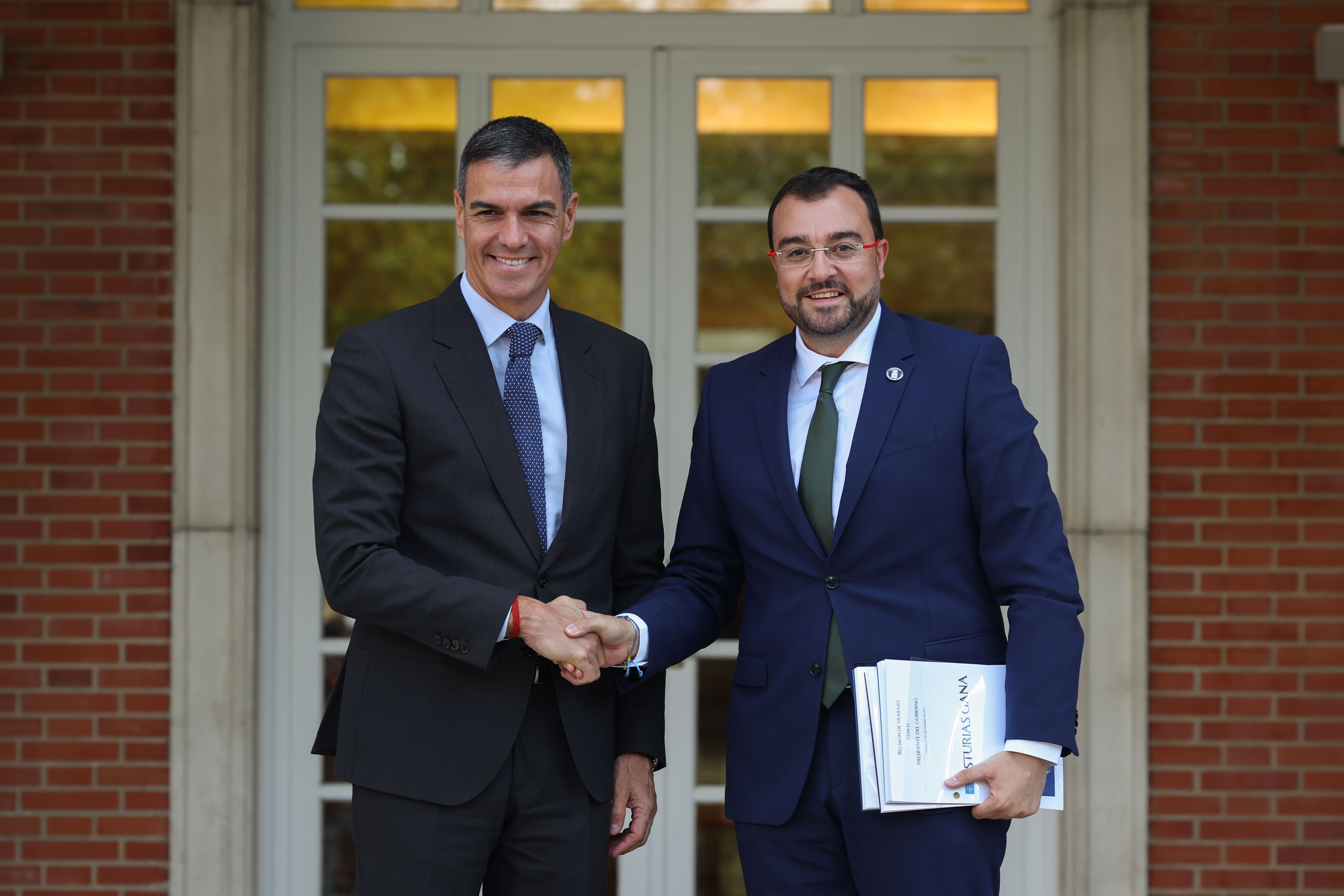 El presidente del Gobierno, Pedro Sánchez, recibe al presidente de Asturias, Adrián Barbón (dcha), a su llegada a la reunión mantenida en el Palacio de la Moncloa este viernes.