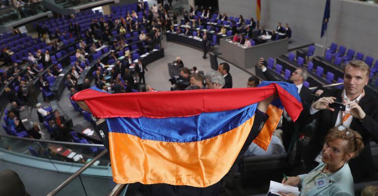 Una persona exhibe una bandera armenia en el Bundestag.