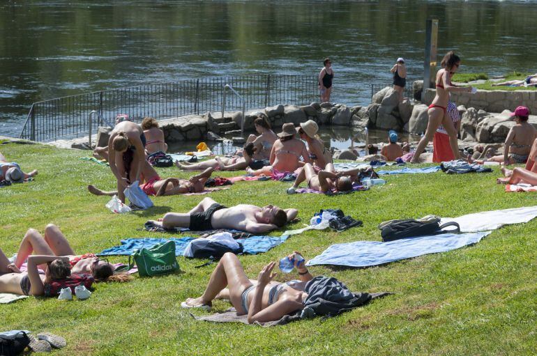 Varias personas disfrutan del buen tiempo en las termas de A Chavasqueira, en Ourense