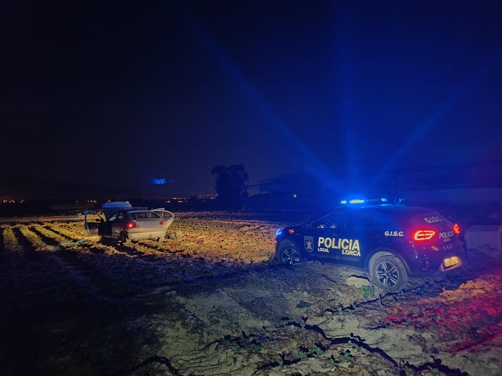 Vehículo policial de Lorca y coche  bloqueado en un terreno de cultivo