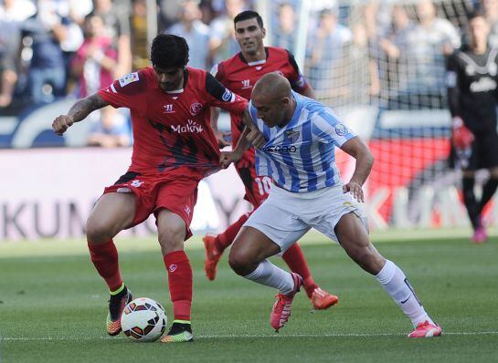 Sevilla&#039;s French defender Timothee Kolodziejczak (L) vies with Malaga&#039;s Argentinian midfielder Fernando Damian Tissone (R)during the Spanish league football match Malaga CF vs Sevilla FC at La Rosaleda stadium in Malaga on May 23, 2015.    AFP PHOTO / CRI