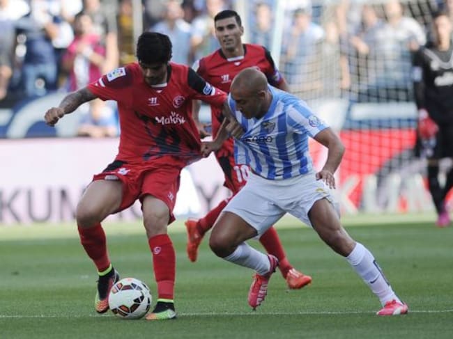Sevilla's French defender Timothee Kolodziejczak (L) vies with Malaga's Argentinian midfielder Fernando Damian Tissone (R)during the Spanish league football match Malaga CF vs Sevilla FC at La Rosaleda stadium in Malaga on May 23, 2015. AFP PHOTO / CRI