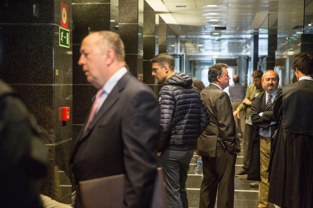 Los acusados, Emilio Titos y su hijo, Emilio José Titos, al fondo y el denunciante, en primer plano, antes de entrar en la sala de vistas