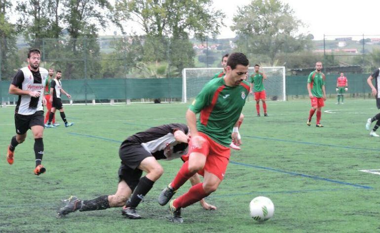 Primo protegiendo el balón frente a un jugador del Meruelo