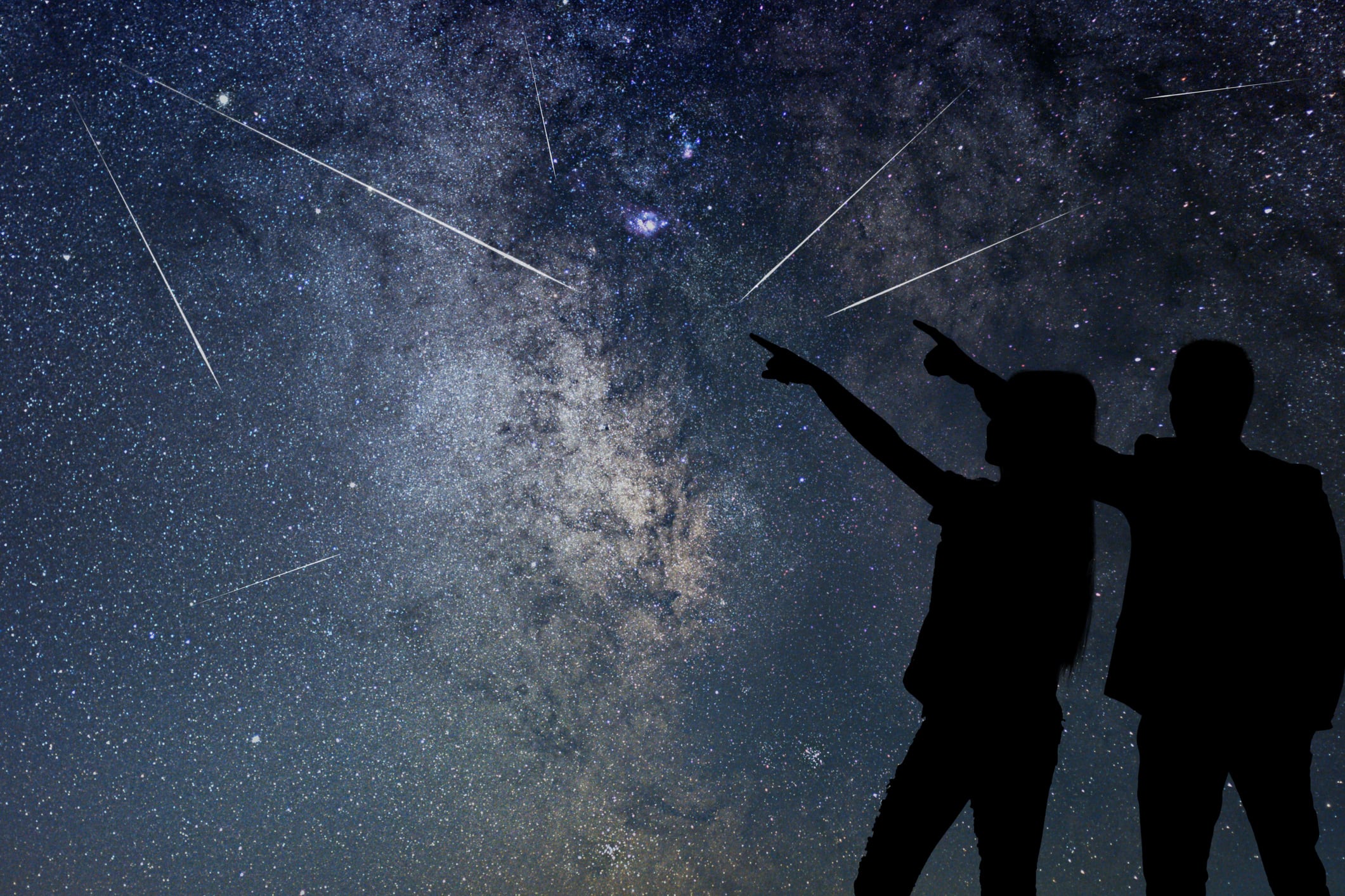 Dos personas observan una lluvia de estrellas.