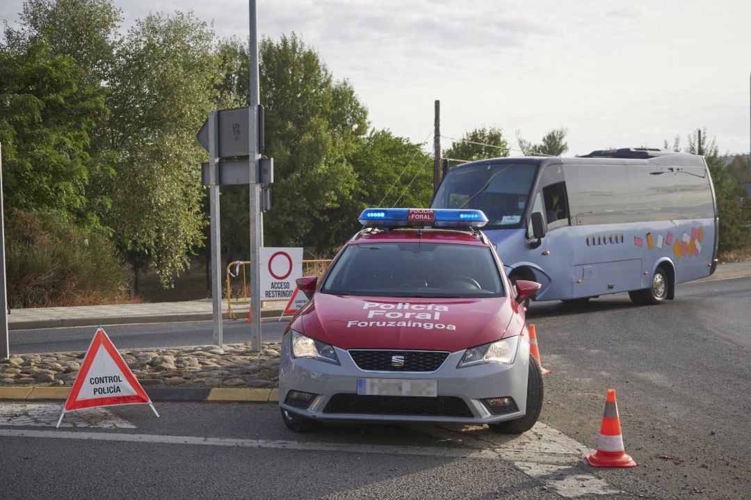 Un coche de policía foral vigila la carretera de entrada a la localidad de Peralta