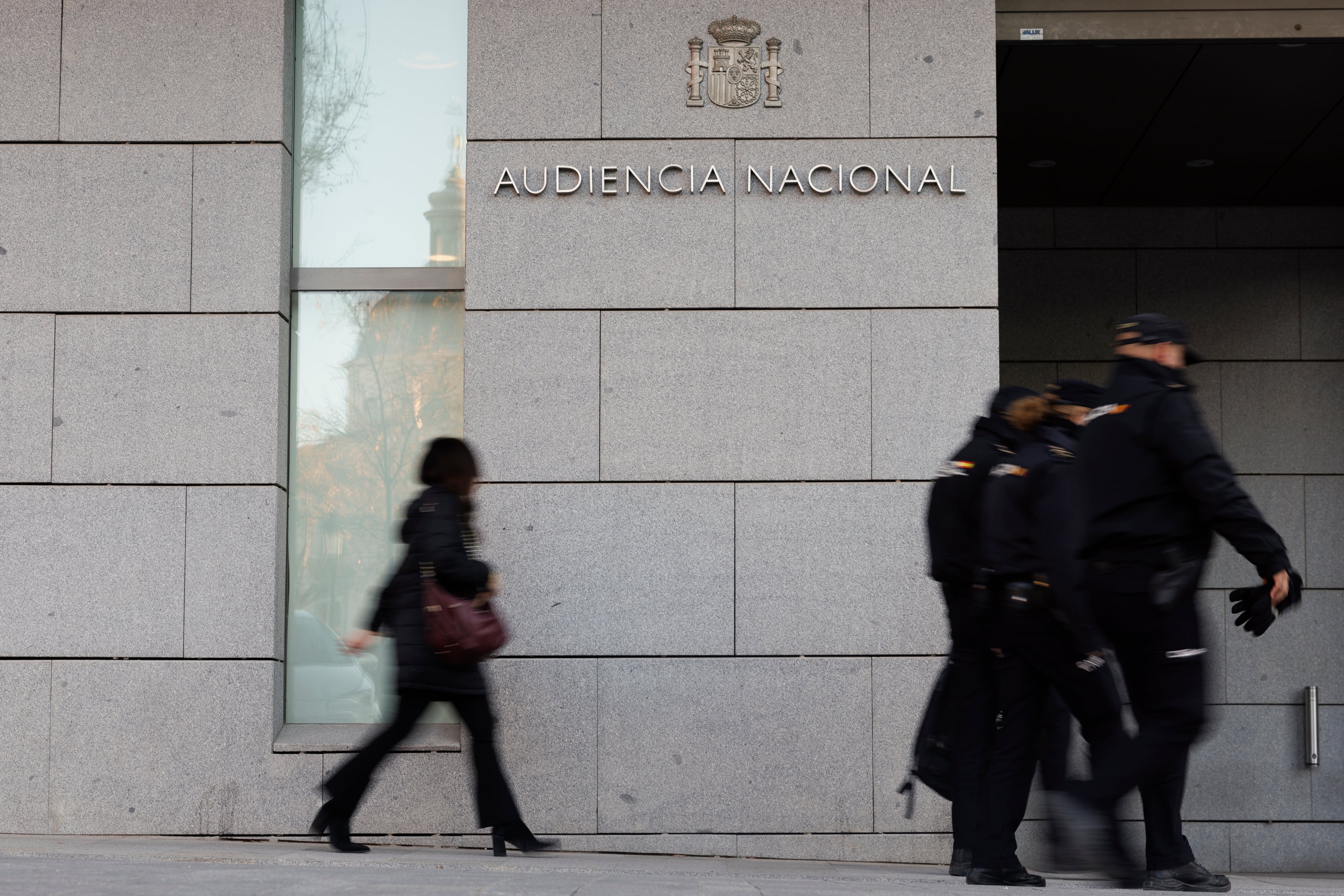 Un grupo de agentes de la Policía Nacional pasan delante de la entrada a la Audiencia Nacional