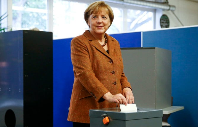 La canciller alemana Merkel emitiendo su voto en un colegio electoral en Berlín