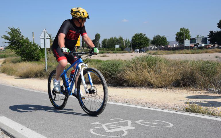 Un ciclista pasa junto a los terrenos en los que hay proyectada una gasolinera junto al río Segura