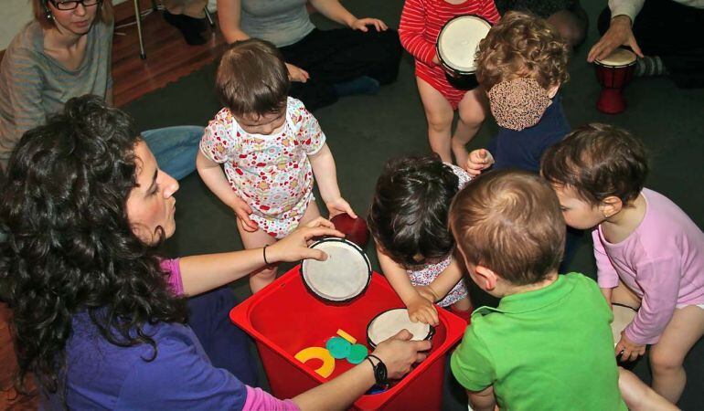 Los progenitores y sus pequeños disfrutan juntos con juegos, actividades e instrumentos musicales