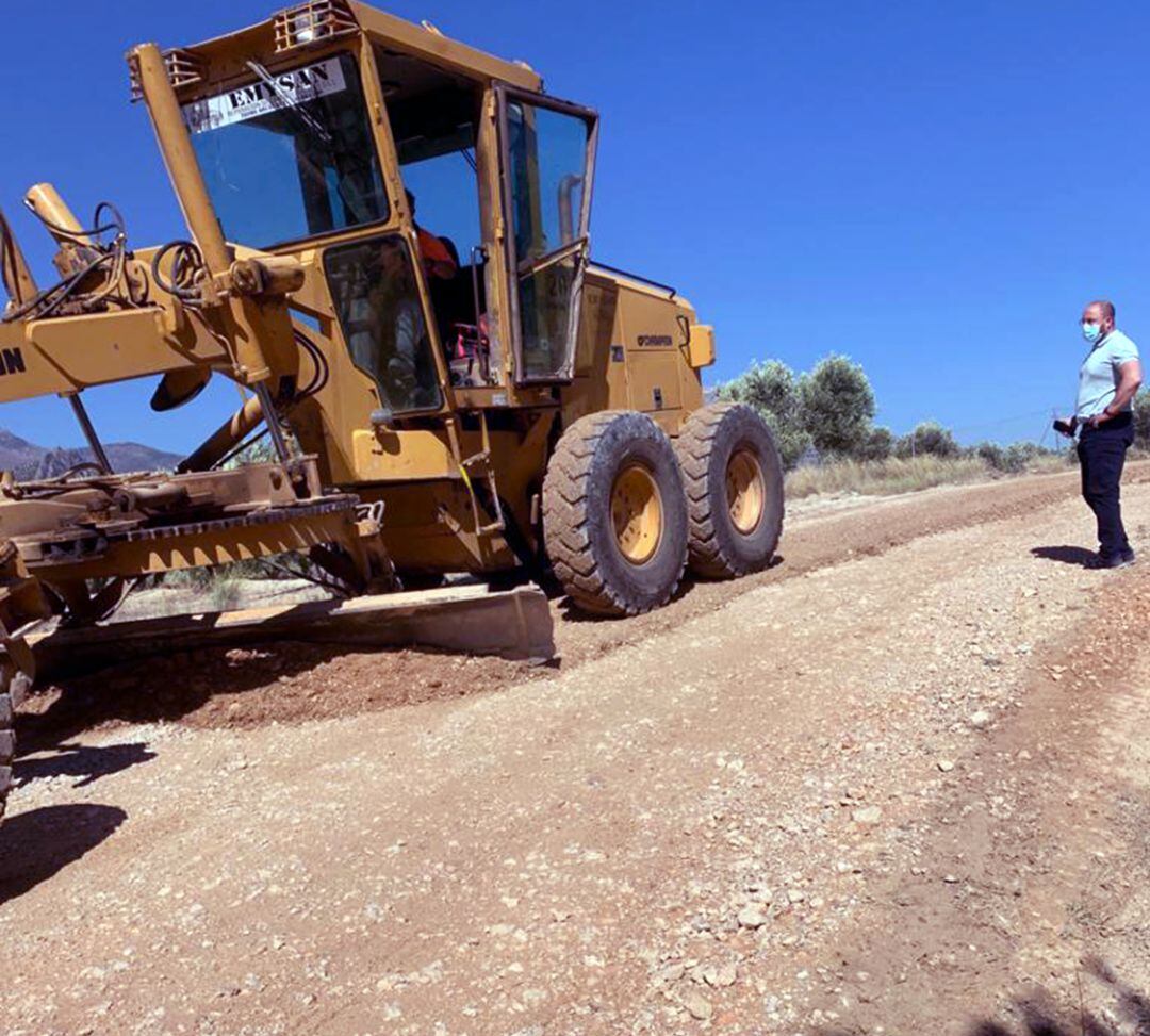 El alcalde de Bedmar, Pablo Ruiz, ante una de la maquinaria en los trabajos en los caminos de Bedmar