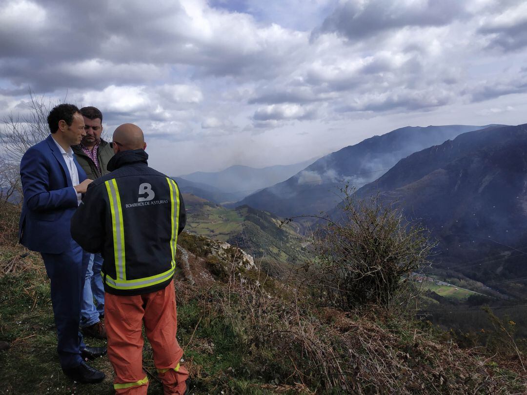 El consejero de Presidencia, Guillermo Martínez observa con personal de Bomberos de Asturias parte de la superficie afectada por el incendio forestal de Salas, uno de los que permanecen activos y de los que más preocupan.