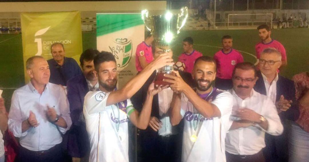 Dos jugadores del Real Jaén recogen la copa de campeones tras ganar el campeonato el año pasado.