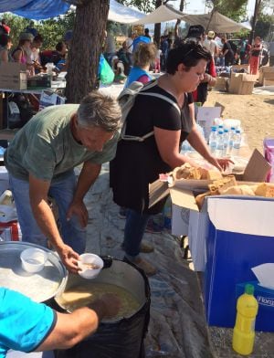 Un grupo de voluntarios ofrece alimentos y bebidas a los refugiados