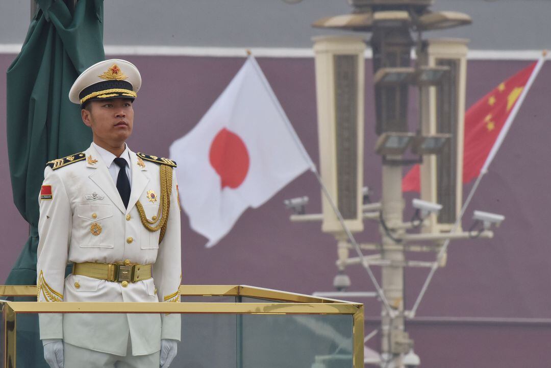 Imagen de archivo de un soldado chino, junto a las banderas de China y Japón, en la plaza de Tiananmen de Pekín, en octubre de 2018.