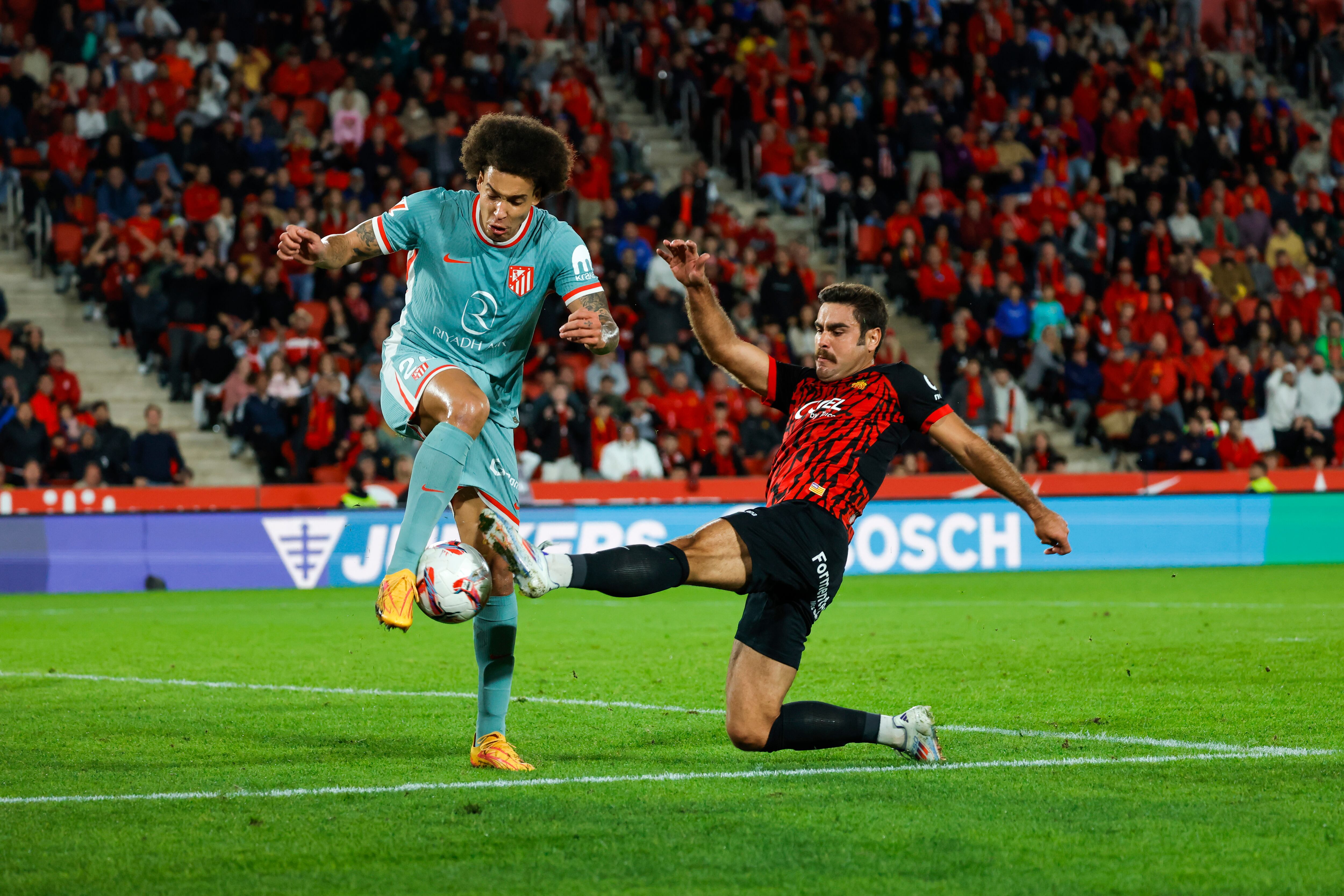 PALMA DE MALLORCA, 10/11/2024.- El delantero del Mallorca Abdón Prats (d) y el defensa belga del Atlético de Madrid Axel Witsel durante el partido de LaLiga entre el Real Mallorca y el Atlético de Madrid, este domingo en el estadio de Soin Moix. EFE/CATI CLADERA
