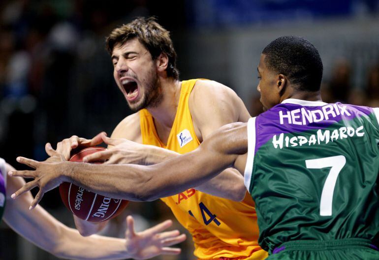 El pívot estadounidense del Unicaja Richard Hendrix, lucha por el balón ante el pivot croata del Barcelona, Ante Tomic