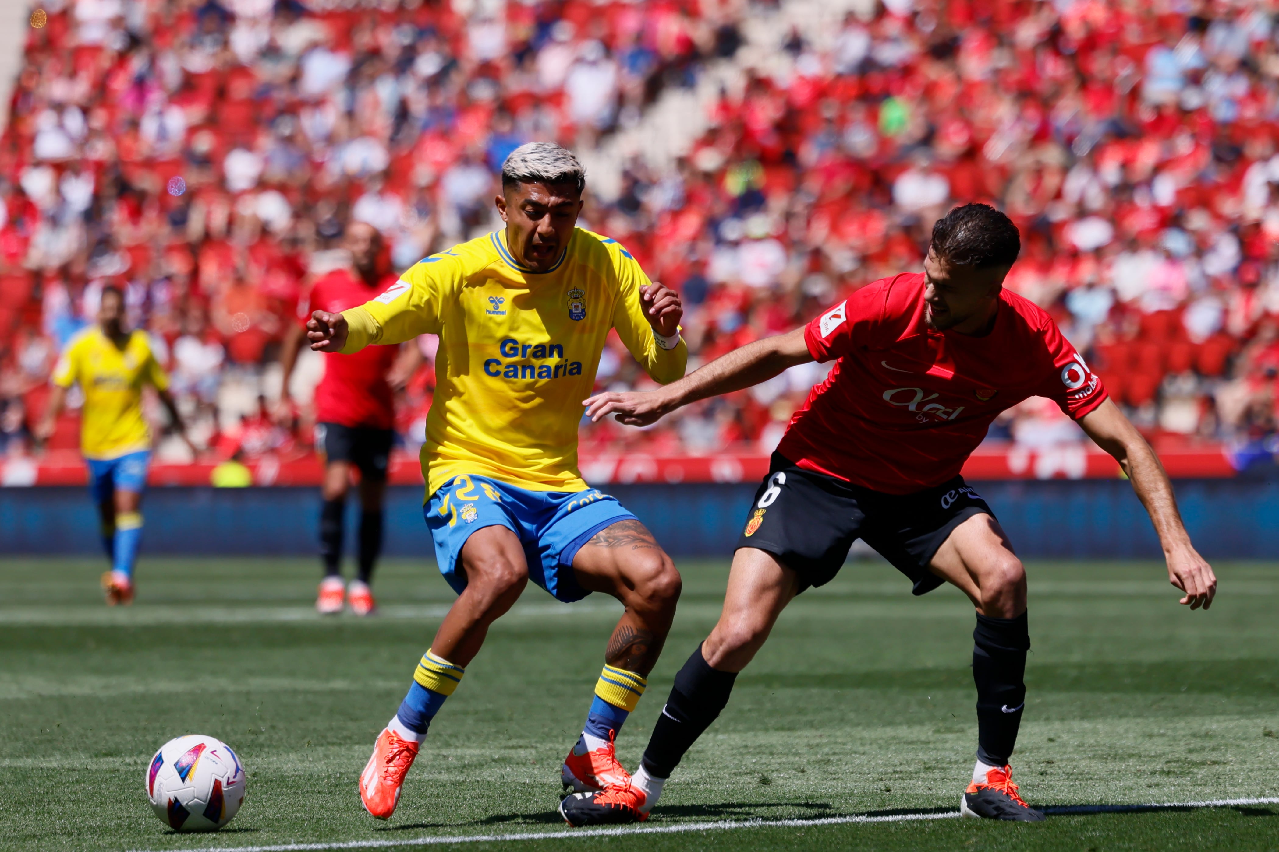 PALMA DE MALLORCA, 11/05/2024.- El defensa de Las Palmas Julián Araujo (i) y el defensa del Mallorca José Manuel Arias Copete durante el partido de la jornada 35 de LaLiga entre el Real Mallorca y U.D Las Palmas, que se disputa este sábado en el estadio de Son Moix en Palma .- EFE/CATI CLADERA
