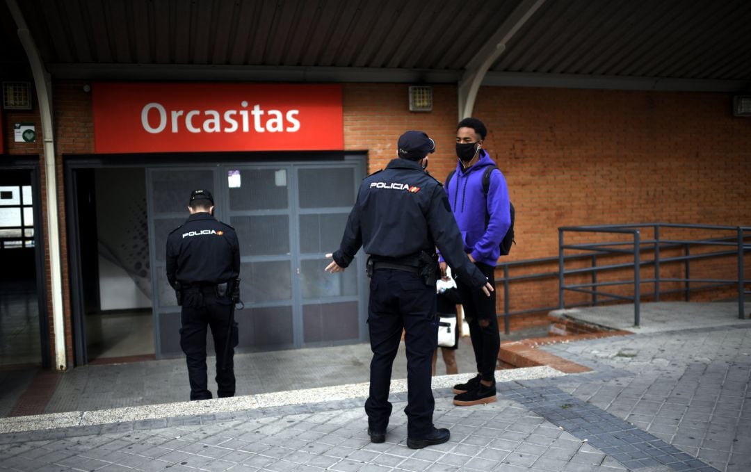 Agentes de la Policía Nacional realizan un control de movilidad en la estación de tren cercanías de Orcasitas, en el distrito de Usera, en Madrid.