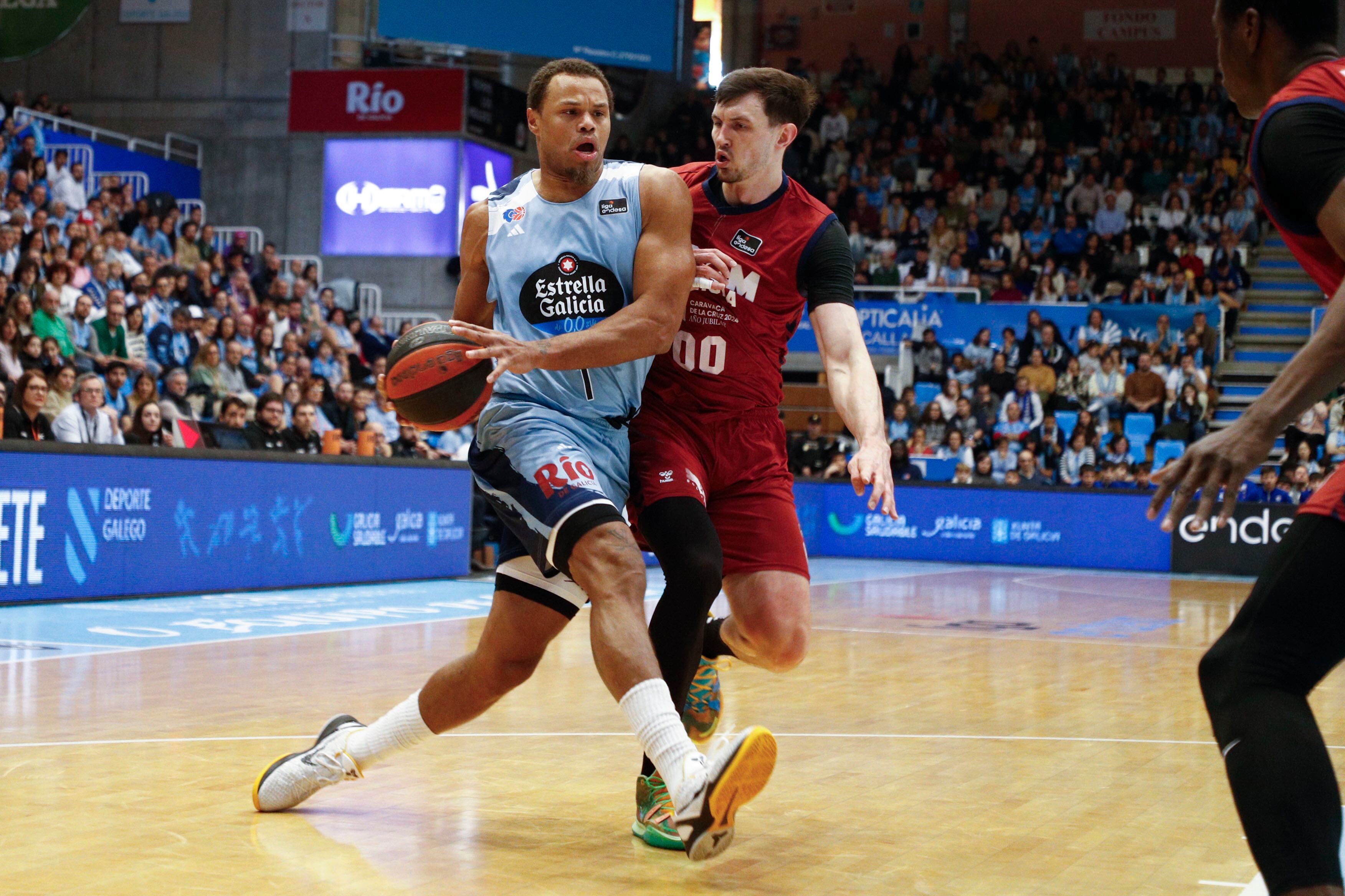 LUGO, 17/12/2023.- El alero estadounidense del Breogán Justin Anderson (i) entra a canasta ante el alero letón del Ucam Murcia Rodions Kurucs (d), durante el partido de la jornada 14 de Liga ACB disputado este domingo en el Pazo Provincial dos Deportes de Lugo. EFE/Eliseo Trigo
