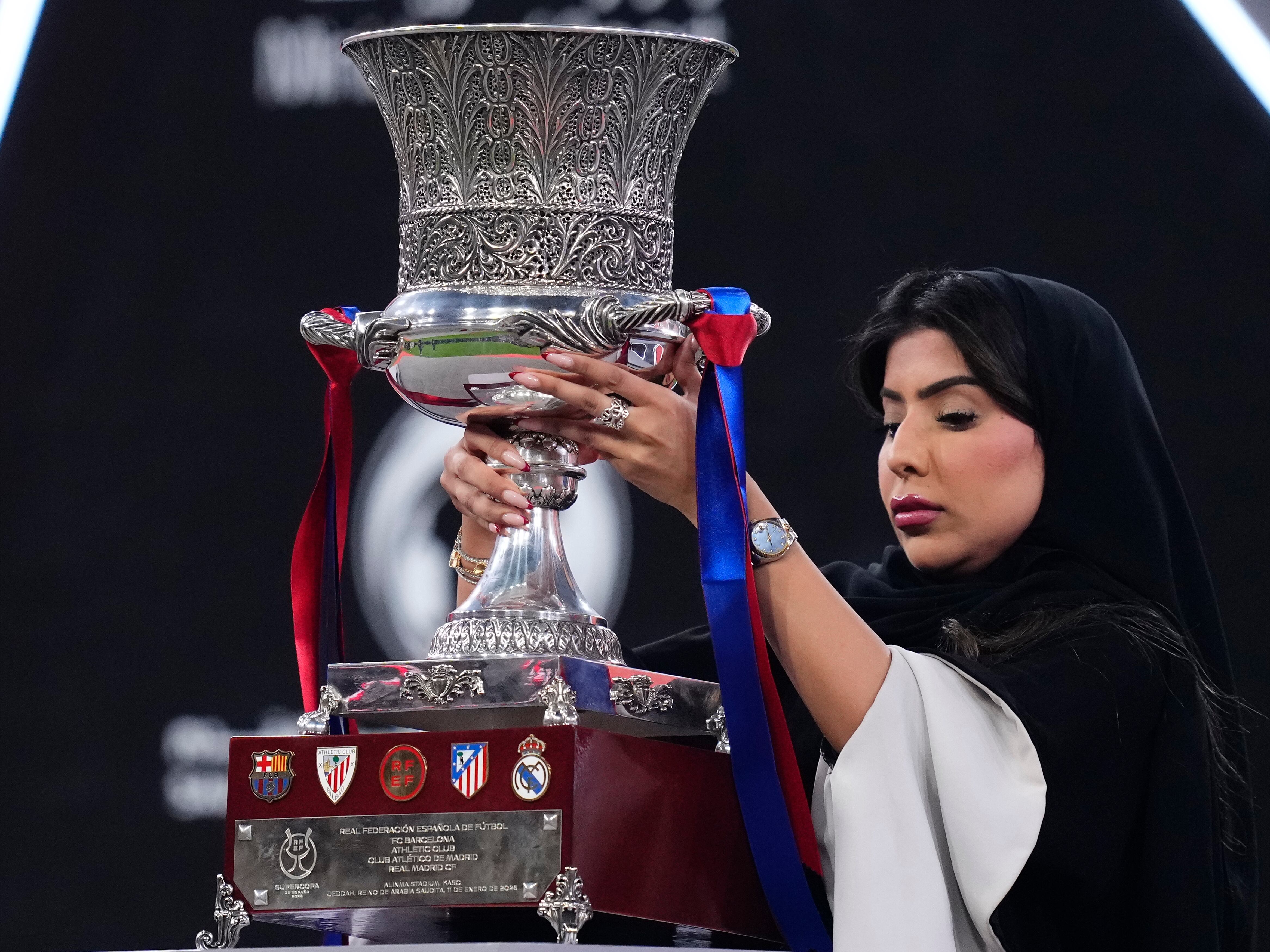 Una mujer lleva el trofeo de la Supercopa de España antes de la final disputada en el King Abdullah Sports City Hall Stadium