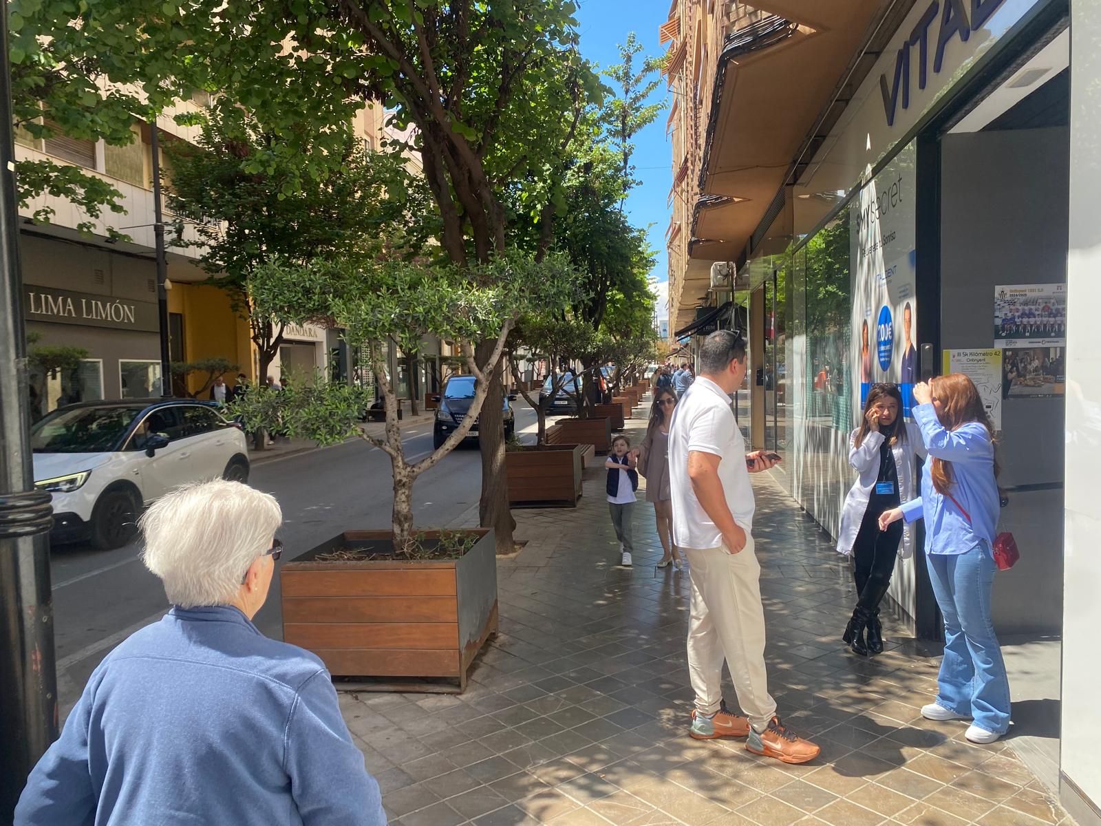 Vecinos y comerciantes esperan en la calle Martínez Valls de Ontinyent tras el apagón, ante la imposibilidad de continuar la actividad en sus negocios