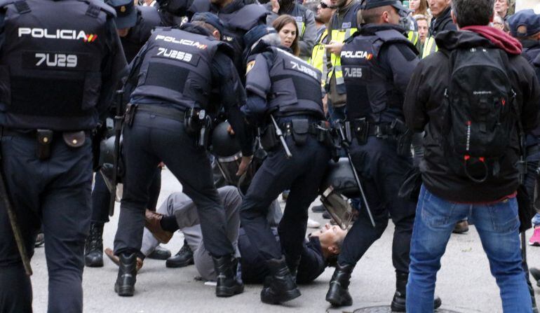 Un manifestant envoltat de policies.