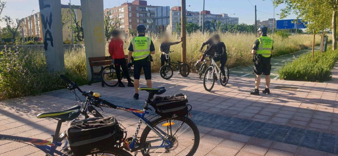 Agentes de la Policía Local informan a unos jóvenes del correcto uso de los espacios al aire libre