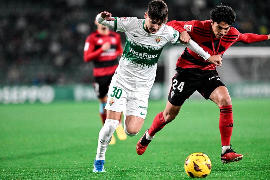 El jugador del Elche Rodrigo Mendoza trata de zafarse de la marca de Jonathan Gómez