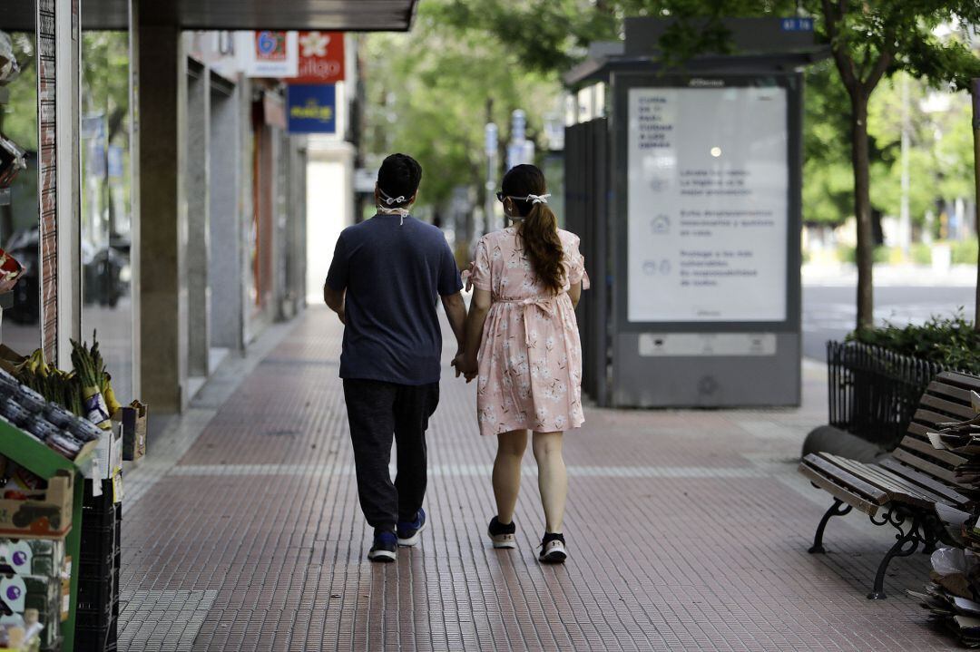 Transeúntes pasean por el centro de la capital, durante el primer día en que los españoles pueden salir de casa a pasear y hacer ejercicio al aire libre