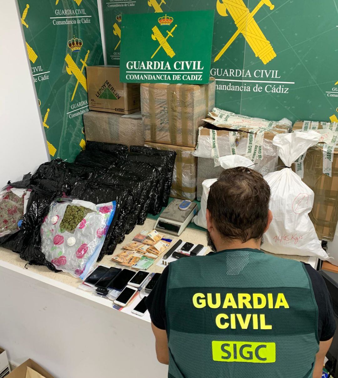 Un Guardia Civil, frente a la mercancía y los objetos incautados a la organización criminal 