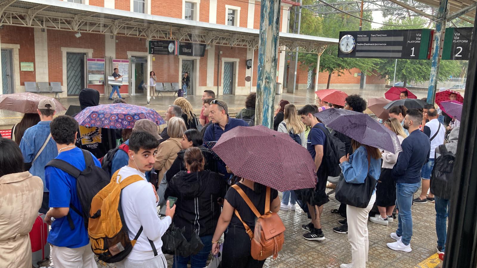 Pasajeros sin poder cruzar las vías por las inundaciones en el paso subterráneo de Renfe en Villena