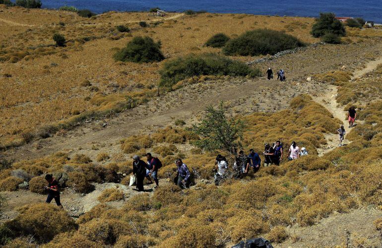Migrantes sirios emprenden su marcha por la costa de Mytilini tras cruzar el Mediterráneo en una lancha neumática hasta llegar a la isla de Lesbos (Grecia).