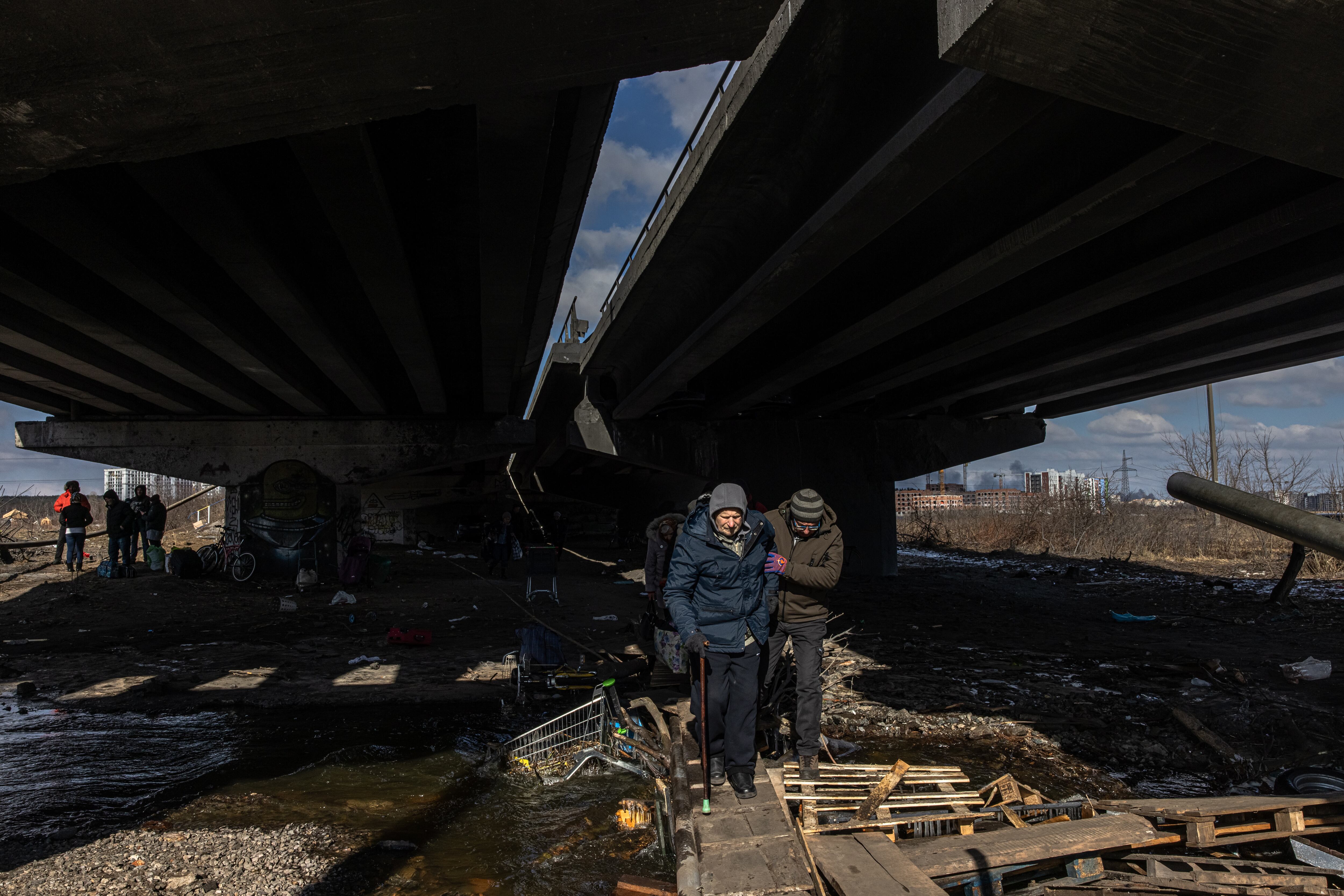 Kyiv (kiev) (Ukraine), 10/03/2022.- Residents cross a destroyed bridge as they flee from the frontline town of Irpin, Kyiv (Kiev) region, Ukraine, 10 March 2022. Thousands of residents are feeling Irpin and Bucha, as well as other settlements near Kyiv which were the most affected by the Russian army invasion. (Rusia, Ucrania, Estados Unidos) EFE/EPA/ROMAN PILIPEY