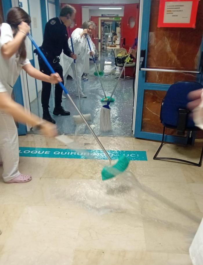 Trabajadoras del Hospital y Policía Local achicando agua la noche del sábado, tras la inundación