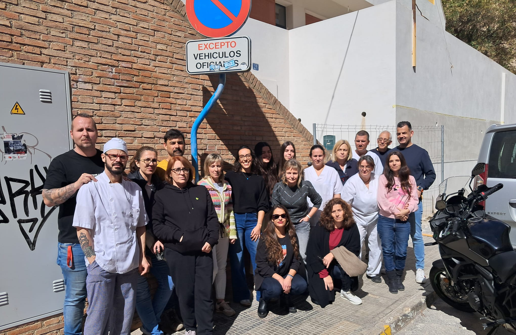 Trabajadores del centro de recepción de menores 'Alacant' ante la valla de acceso a la obra de rehabilitación del edificio aún por acabar