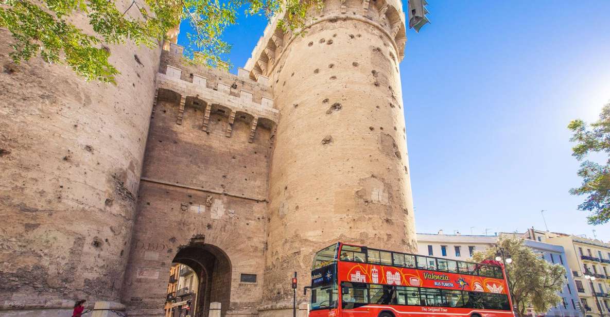 Una unidad del Bus Turístic de València circula por las inmediaciones de uno de los monumentos históricos de la ciudad, las torres de Quart