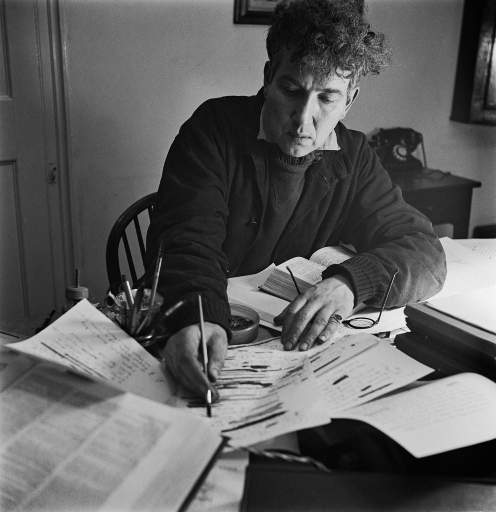 English poet, novelist, essayist and critic, Robert von Ranke Graves (1895 - 1985) writing at Vale House, his home in Galmpton near Brixham, Devon, December 1941. Original Publication: Picture Post - 982 - What I Believe About Ghosts - pub. 27th December 1941. (Photo by Bill Brandt/Picture Post/Hulton Archive/Getty Images)