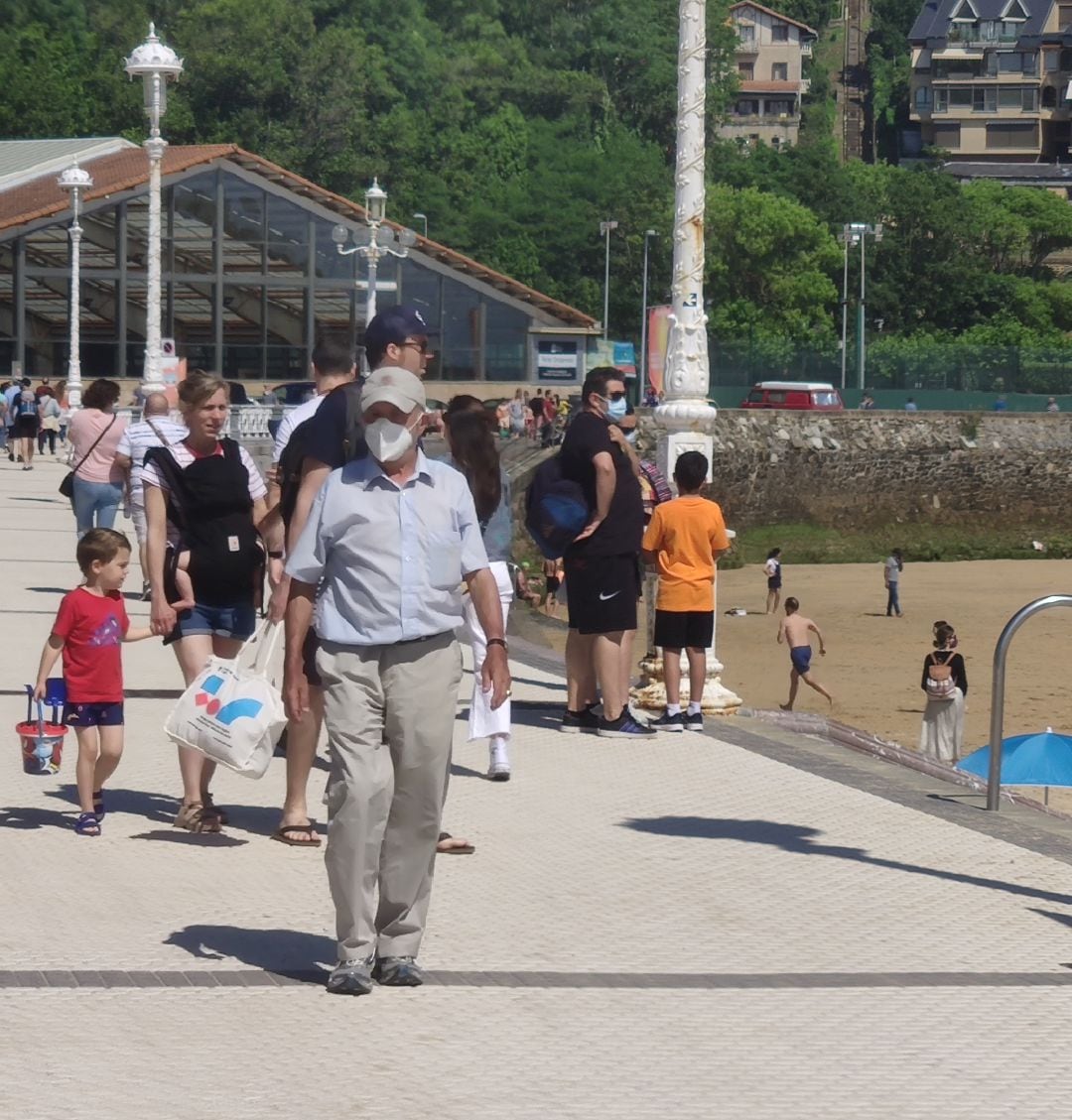 Ciudadanos con y sin mascarilla pasando por la playa de Ondarreta en san Sebastián en el primer día en el que se puede ir sin mascarilla en el exterior