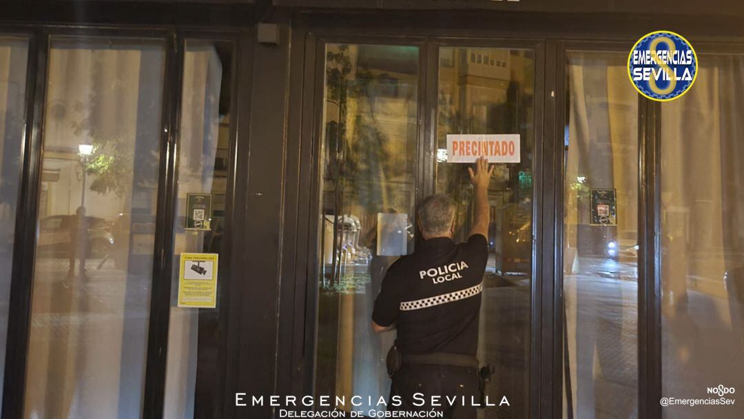 Agente de la Policía Local de Sevilla poniendo el precinto a un local que era reincidente en los incumplimientos