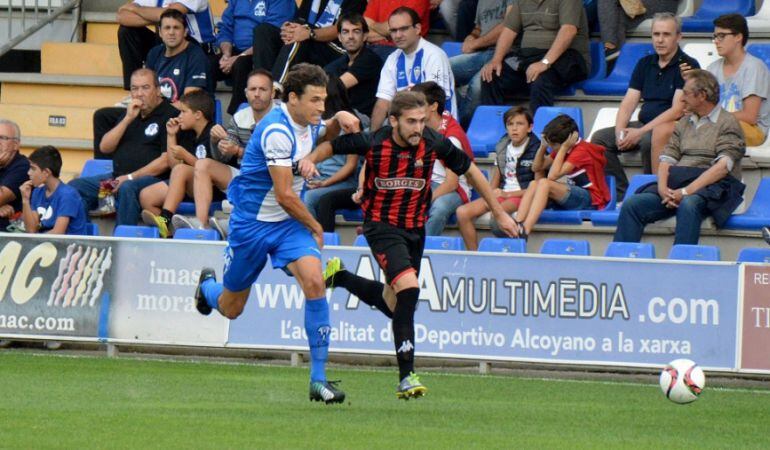 Albert Benito disputant una pilota amb un jugador de l'Alcoyano.