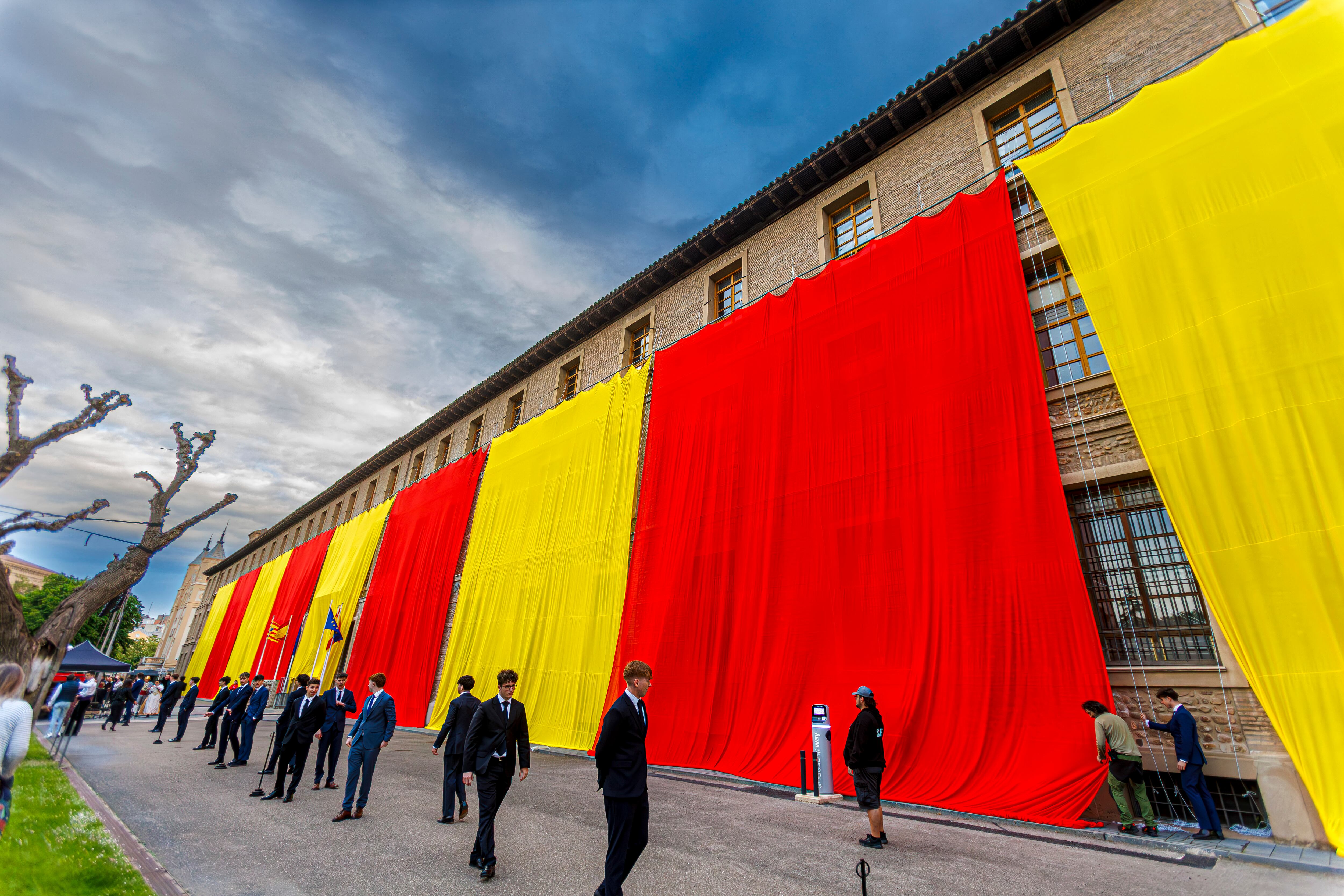 ZARAGOZA, 20/04/2025.- El Gobierno de Aragón ha dado comienzo a los actos de la festividad de San Jorge, patrón de Aragón, con la extensión de en la fachada de su sede de una bandera de Aragón. EFE/JAVIER BELVER

