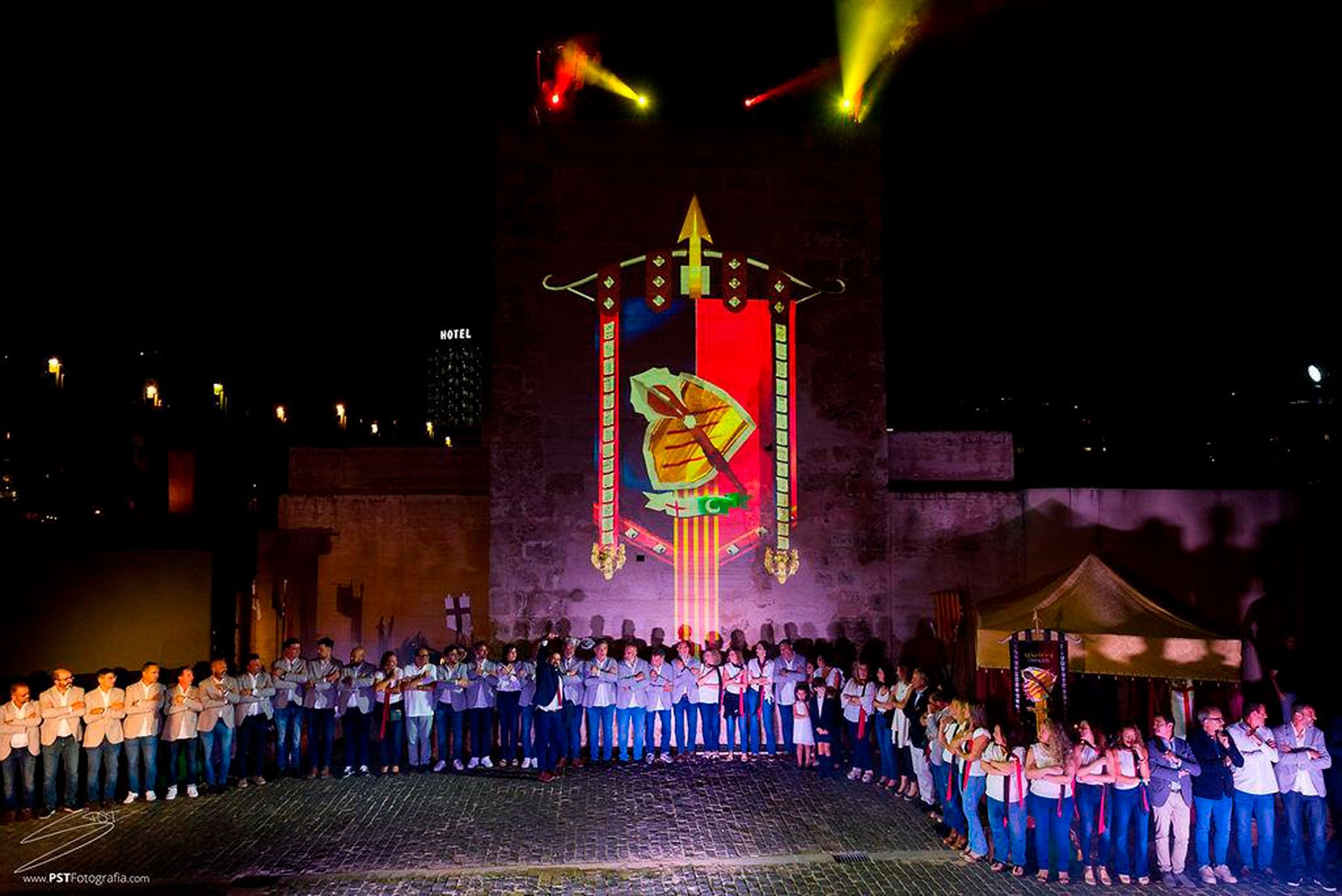 Imatge general dels participants i de l&#039;heràldica projectada sobre la Torre Na Valora